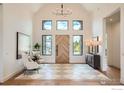 Bright entryway with soaring ceilings, designer tile floors and a stunning wooden door at 1126 W Enclave Cir, Louisville, CO 80027