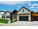 Modern home exterior showcases a stylish stone facade, dark accents, and an attached two-car garage at 1126 W Enclave Cir, Louisville, CO 80027