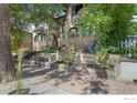 Charming brick home featuring mature trees, manicured flower beds, and a welcoming front porch at 1217 N Downing St # 4, Denver, CO 80218