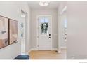 Bright entryway showcasing hardwood floors, a stylish front door, and elegant decor at 1425 Burt Ave, Berthoud, CO 80513