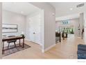 Open hallway view featuring wood floors, a study nook, and a glimpse into the living area at 1425 Burt Ave, Berthoud, CO 80513