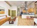 Modern open-concept living area with hardwood floors, kitchen island, and comfortable seating at 1455 Yarmouth Ave # 211, Boulder, CO 80304