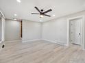 Open-concept living room featuring a ceiling fan and beautiful light wood flooring at 1475 S Eaton St, Lakewood, CO 80232