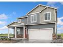 View of a two-story home with gray siding, stone accents, and a two-car garage at 1639 Pinnacle Ave, Lochbuie, CO 80603