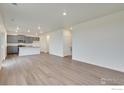 Spacious living room with open layout, hardwood floors, and modern gray cabinets at 1639 Pinnacle Ave, Lochbuie, CO 80603