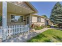 Inviting front porch with a picket fence and landscaped garden at 2156 Collyer St, Longmont, CO 80501