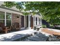 Inviting front porch with stone accents, a seating area, and manicured landscaping at 268 S Buchanan Cir, Louisville, CO 80027