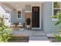 Inviting front porch with stone accents, seating area, and a beautifully decorated entrance at 2830 Cascade Creek Dr, Lafayette, CO 80026