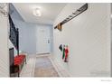 Bright entryway featuring tiled floors, coat rack, and staircase at 32 Powder Horn Pl, Longmont, CO 80504