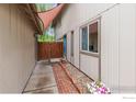 Side exterior view featuring a walkway, fenced yard, and covered entrance at 32 Powder Horn Pl, Longmont, CO 80504