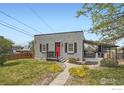 Well-maintained home with a lush green lawn, mature landscaping, and a stone pathway to the entrance at 4009 W 52Nd Ave, Denver, CO 80212