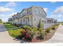 Landscaped yard with vibrant roses and white picket fence enhance the curb appeal of these townhouse-style homes at 450 Canadian Crossing Dr, Longmont, CO 80504