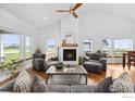 Bright living room featuring vaulted ceiling, fireplace, and lots of natural light at 505 Nesting Eagles Way, Berthoud, CO 80513