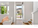 Bright foyer with hardwood floors, a sunlit window with view, and an open door at 5341 Warrior St, Frederick, CO 80504