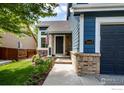 Inviting front entrance featuring brick accents, manicured landscaping, and a well-maintained walkway to the door at 5609 Mount Sanitas Ave, Longmont, CO 80503
