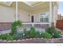 Inviting covered front porch with garden and attractive landscaping at 7755 Halleys Dr, Littleton, CO 80125