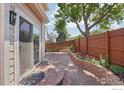 Relaxing brick patio with landscaped flower beds and a well-maintained fence at 7755 Halleys Dr, Littleton, CO 80125