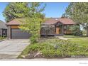 Ranch home featuring well-maintained landscaping and an attached garage at 916 W Alder St, Louisville, CO 80027