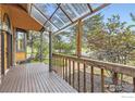 View from the porch showcasing the wooden railings, clear roof, and surrounding greenery at 916 W Alder St, Louisville, CO 80027