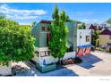 An aerial view of a stylish home with colorful window frames, lush trees, and a well-maintained exterior at 1028 Katy Ln, Longmont, CO 80504