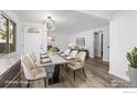 Staged dining area featuring a sleek modern table, soft lighting, and stylish decor with newly installed floors at 1111 Wabash St, Denver, CO 80220