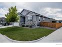 Well-maintained home showcasing stone detailing and a lush green lawn, situated on a corner lot at 14605 Longhorn Dr, Mead, CO 80542