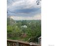 Scenic view of lush backyard and trees from the deck, offering privacy and a connection with nature at 14751 E 24Th Ave, Aurora, CO 80011