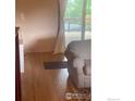 Cozy living room featuring a sliding glass door to deck, hardwood floors, and comfortable armchair at 14751 E 24Th Ave, Aurora, CO 80011