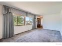 Spacious living room features plush carpet, large window with ornate drapes, and neutral walls at 1951 S Deframe Way, Lakewood, CO 80228