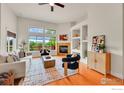 Bright living room featuring a fireplace, large windows, and stylish decor at 2226 Eagles Nest Dr, Lafayette, CO 80026