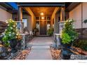 Inviting front porch features stone columns, stylish lighting, and decorative flowerpots at 2659 Heron Lakes Pkwy, Berthoud, CO 80513