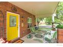 Inviting front porch with brick columns, porch swing, seating, and decorative elements at 301 E Colorado Ave, Berthoud, CO 80513