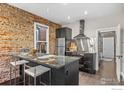 Stylish kitchen with granite counters, stainless steel appliances, exposed brick and modern fixtures at 3321 Navajo St, Denver, CO 80211