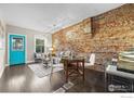Cozy living room with exposed brick, bright window, and a pop of color with the turquoise door at 3321 Navajo St, Denver, CO 80211