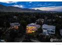 A stunning home stands out with balconies and large windows amidst the night lights and mountain view at 3747 Mountain Laurel Pl, Boulder, CO 80304