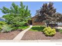 Brick house showcasing mature landscaping, including trees and shrubs in well-maintained front yard at 4720 S Grant St, Englewood, CO 80113