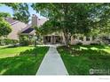 Exterior of condo building featuring mature trees and a well-manicured lawn at 5920 Gunbarrel Ave # D, Boulder, CO 80301