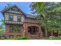 Charming two-story home with a brick facade and covered porch with plants at 604 Mapleton Ave, Boulder, CO 80304