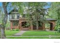 Charming two-story home with a brick facade, covered porch and manicured green lawn at 604 Mapleton Ave, Boulder, CO 80304