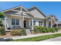 Charming home with a covered porch, landscaped front yard, and neutral-colored siding on a sunny day at 871 Colorado River Ave, Brighton, CO 80601