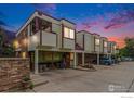 Multi-Gathering home at twilight with a mix of brick and siding, and reserved parking spots at 911 Tulip St # C, Longmont, CO 80501