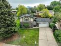 An elevated view of a brick accented home with a well-manicured lawn and lush greenery at 9642 Meade Ct, Westminster, CO 80031