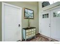 Inviting foyer featuring a vintage dresser with two white doors and a decorative painting at 9642 Meade Ct, Westminster, CO 80031