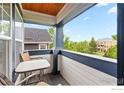 A cozy balcony featuring outdoor seating with views of lush greenery and a blue sky at 1043 Terrace S Cir, Boulder, CO 80304