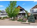 A charming two-story home featuring a cozy front porch, mature trees, and professionally landscaped front yard at 1043 Terrace S Cir, Boulder, CO 80304