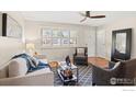 Bright living room boasts large windows, hardwood floors, and stylish furnishings, creating a comfortable and inviting atmosphere at 10844 W 68Th Ave, Arvada, CO 80004