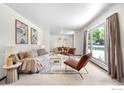 Bright living room featuring neutral walls, plush carpet, modern furniture, and abundant natural light from large windows at 11198 W 59Th Pl, Arvada, CO 80004