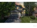 Charming two-story home with a well-manicured lawn and illuminated by warm lights at dusk at 13673 Cook St, Thornton, CO 80602