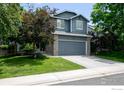 Inviting two-story home with lush front yard, mature trees, and an attached two-car garage at 13836 Harrison Dr, Thornton, CO 80602