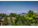 Breathtaking mountain views from this home nestled among lush trees at 14448 Hanover St, Brighton, CO 80602